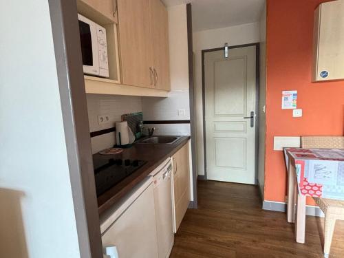 une petite cuisine avec un évier et un micro-ondes dans l'établissement Appartement 2 pièces, piscine, golf - FR-1-504-680, à Saint-Raphaël