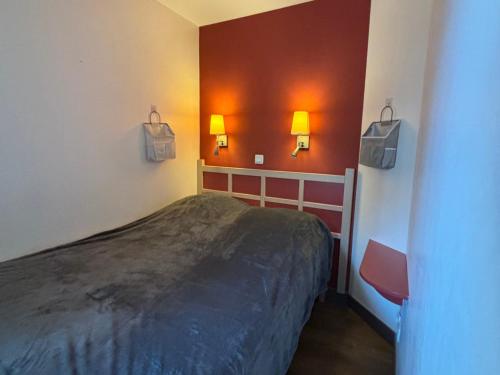 Cette chambre comprend un lit et deux lumières sur le mur. dans l'établissement Appartement 2 pièces, piscine, golf - FR-1-504-680, à Saint-Raphaël