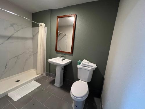 a bathroom with a toilet and a sink and a mirror at Comfort stay inn in Quincy