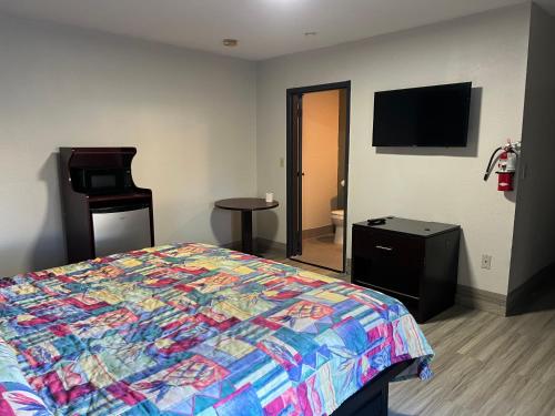Schlafzimmer mit einem Bett und einem Flachbild-TV in der Unterkunft Comfort stay inn in Quincy