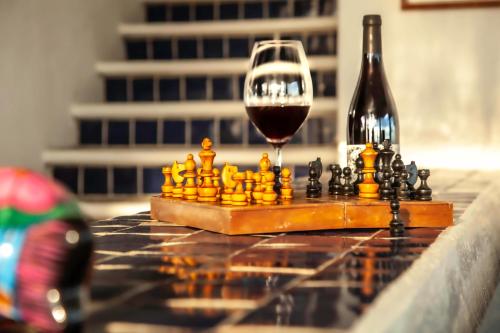 a chess board and a glass of wine on a table at Villas Mykonos in Zipolite