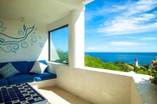 a room with a blue couch and a view of the ocean at Villas Mykonos in Zipolite