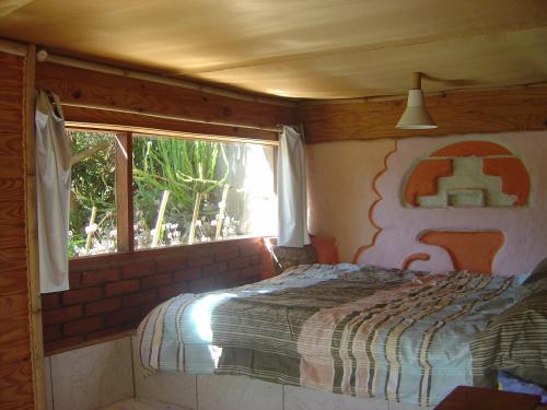 um quarto com uma cama e uma janela numa casa em Orgânica-Mente B&B em Viscode de Mauá