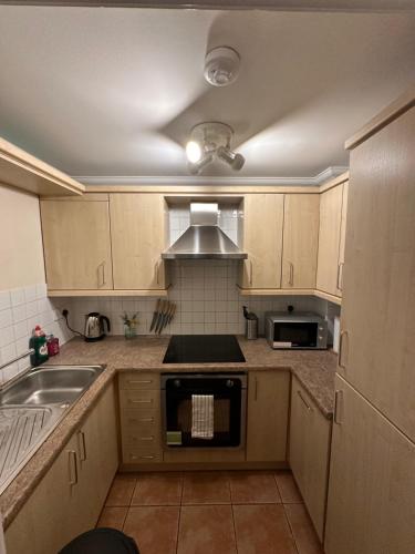 a kitchen with wooden cabinets and a stove top oven at Fitzroy Royale Apart- London in London