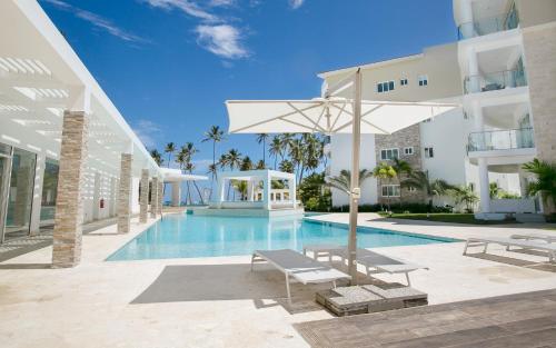 蓬塔卡納的住宿－Destination Jelly / Playa Coral Condo，一座带游泳池和遮阳伞的别墅