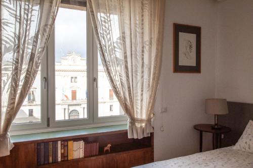 a bedroom with a window with a view of a building at Dimore Santojanni - Il Salotto dei Portici nel centro di Potenza in Potenza