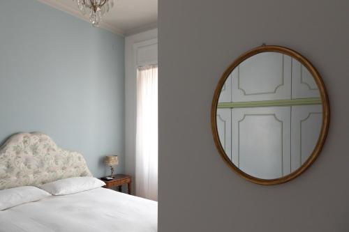 a bedroom with a mirror on the wall and a bed at Dimore Santojanni - Il Salotto dei Portici nel centro di Potenza in Potenza