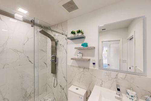 a bathroom with a shower and a sink and a mirror at Angler's Escape in Marathon