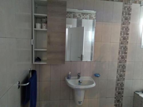 Appartement moderne, vue mer في هرقلة: حمام مع حوض ومرآة