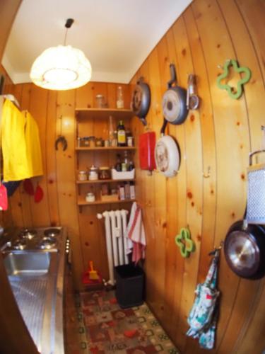 a kitchen with wooden walls with pots and pans on the wall at Bardonecchia, monolocale, ottima posizione. in Bardonecchia