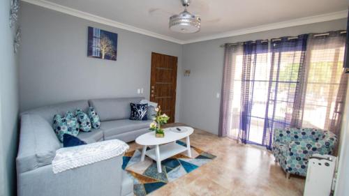 uma sala de estar com um sofá e uma mesa em Nely y Pietro share apartment em Punta Cana