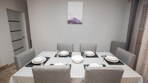 a dining room with a table with chairs and plates at Nely y Pietro share apartment in Punta Cana