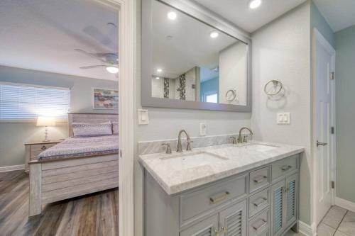 Un baño con lavabo, espejo y cama. en Four Shores Unit 1 Beach Condo Direct Gulf with Pool & Spa, en Clearwater Beach