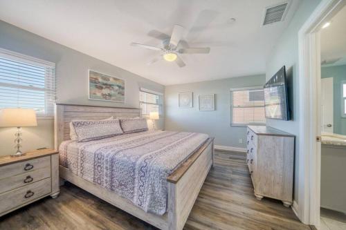 Un dormitorio con una cama y un ventilador de techo. en Four Shores Unit 1 Beach Condo Direct Gulf with Pool & Spa, en Clearwater Beach