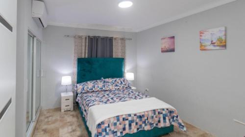 1 dormitorio con 1 cama con cabecero verde en Nely y Pietro share apartment, en Punta Cana