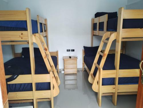 a room with three bunk beds with blue sheets at Casa Maikai Tarapoto in Tarapoto