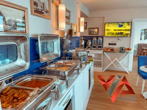 una cocina con varias bandejas de comida en un mostrador en VIP CLASS ꙳ ORBI CITY, en Batumi