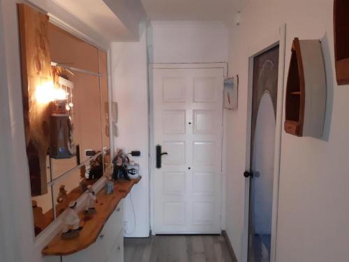 a bathroom with a sink and a mirror and a door at Apartamento Pineda in La Pineda
