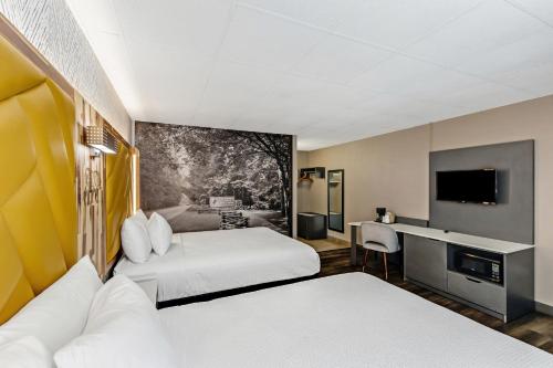 a hotel room with two beds and a television at The Wander Hotel in Gatlinburg