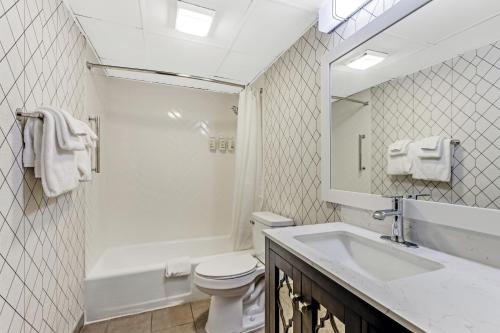 a bathroom with a toilet and a sink and a mirror at The Wander Hotel in Gatlinburg
