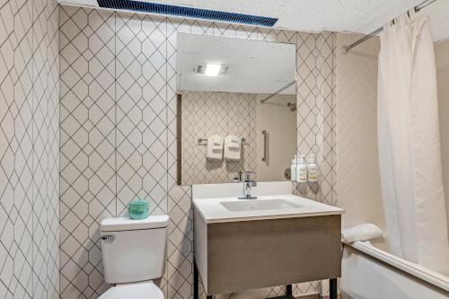 a bathroom with a sink and a toilet and a mirror at The Wander Hotel in Gatlinburg
