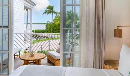um quarto de hotel com uma cama e uma varanda em Islander Bayside Villas & Boatslips em Islamorada