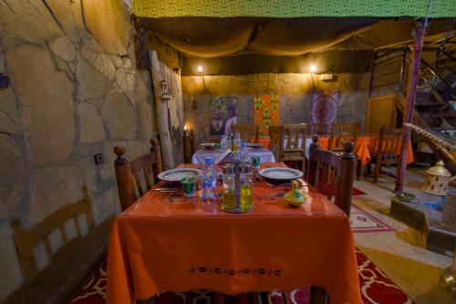 a dining room with a table with orange table cloth at Tin Joseph in Ouarzazate