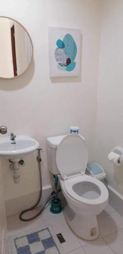 a bathroom with a white toilet and a sink at Lovely Homes at Casa Mira Bacolod in Bacolod