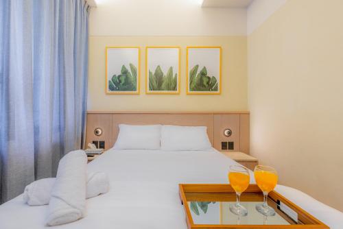 a bedroom with a bed and two glasses on a table at Capitalia Palacio Polanco in Mexico City