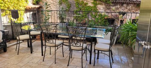 a glass table and chairs on a patio at Maison de 6 pièces au coeur du village d'Eze in Èze