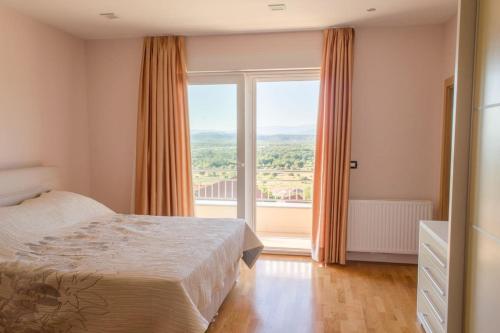 um quarto com uma cama e uma grande janela em Villa Marija em Ljubuski