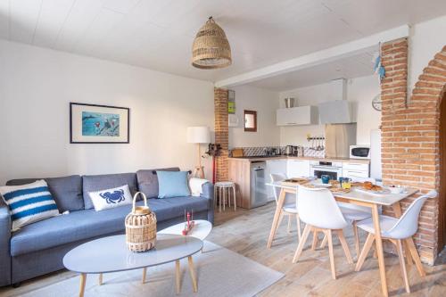 un salon avec un canapé bleu et une table dans l'établissement Le Refuge d'Arsène - Echappée sur l'Aiguille, à Étretat