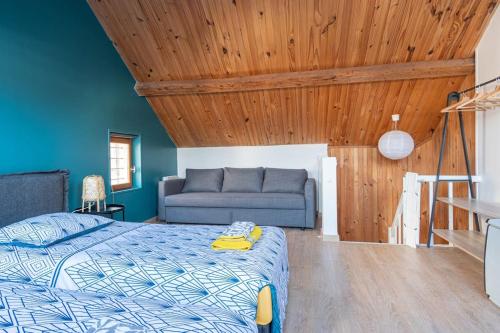 une chambre avec un lit et un canapé dans l'établissement Le Refuge d'Arsène - Echappée sur l'Aiguille, à Étretat