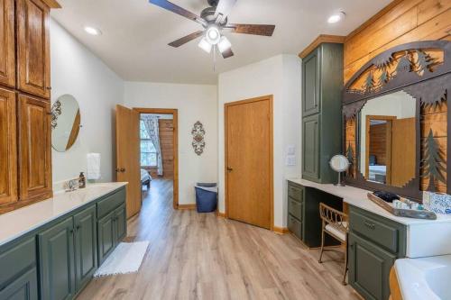 uma casa de banho com armários verdes e uma ventoinha de tecto em Luxe Hot Springs Cabin w/Pond and Game Room! em Pearcy