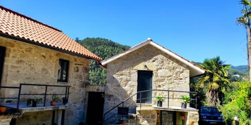 an old stone house with palm trees in the background at Quinta da Eira in Sever do Vouga