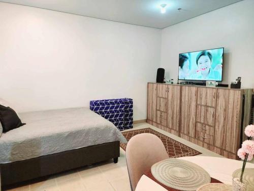 Schlafzimmer mit einem Bett und einem Flachbild-TV in der Unterkunft Casa De Castillo in Marilao