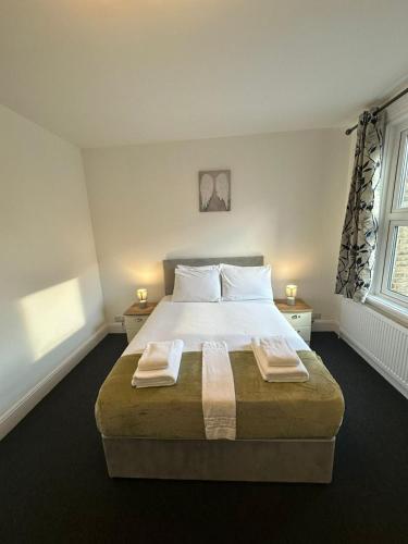 a bedroom with a large bed with two towels on it at Cambridge Central Rooms - Tas Accommodations in Cambridge