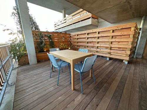 einen Holztisch und Stühle auf einer Terrasse in der Unterkunft SKY - ASNIERES in Asnières-sur-Seine