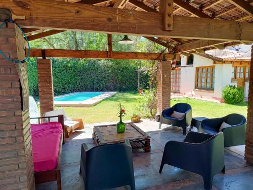 un patio con sillas, una mesa y una piscina en Posada del. Huerto en Luján de Cuyo