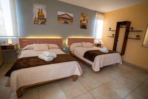 a bedroom with two beds with towels on them at Hermoso departamento amueblado en Aguascalientes. Céntrico in Aguascalientes