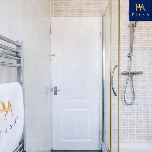 a bathroom with a shower and a white door at 3 Bed by Birmingham Airport in Birmingham