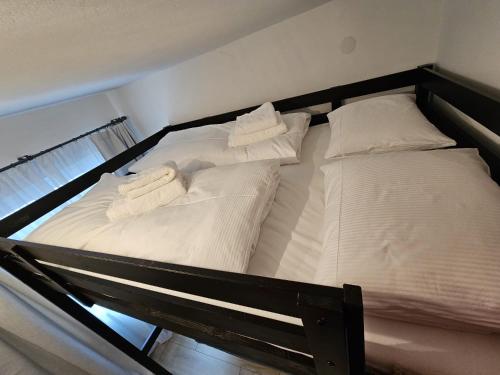 dwa łóżka z białą pościelą i poduszkami na nich w obiekcie Cozy studio in Hinterglemm w Saalbach Hinterglemm