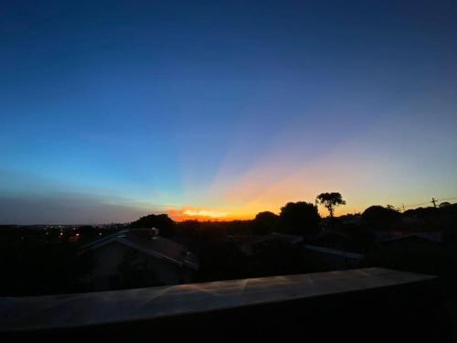 a sunset in the sky with a tree in the foreground at Sobrado aconchegante e espaçoso, ótima opção! in Foz do Iguaçu