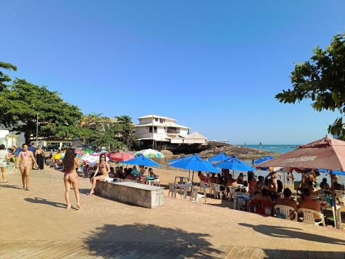 a group of people walking on a beach with umbrellas at Casa Temporada peterle Iriri in Iriri