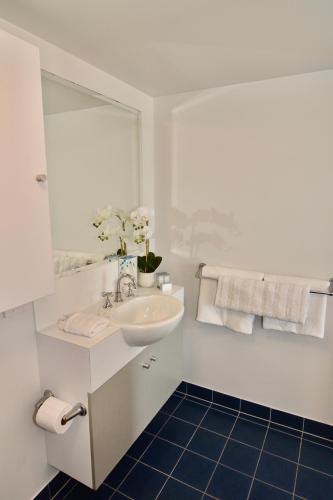 a white bathroom with a sink and a mirror at City Stadium 2 in Townsville