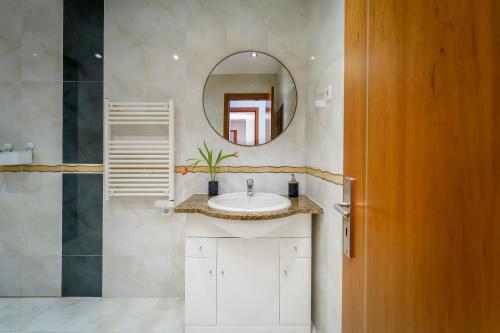 a bathroom with a sink and a mirror at Lovely&Cozy apartment in Lagoa