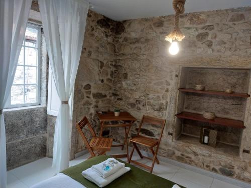 a bedroom with a bed and a table and a window at A Taberna de Gundián in Vedra
