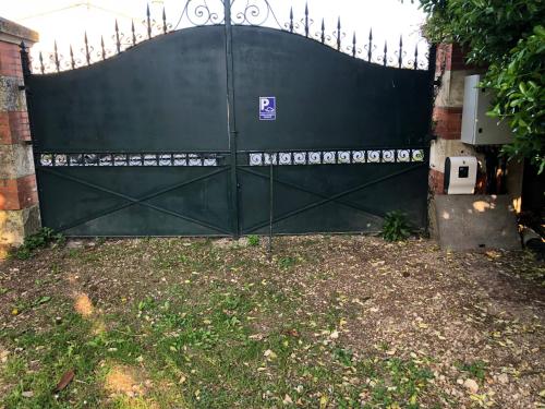 a green gate in a yard next to a house at Le Logis de Vallans in Vallans