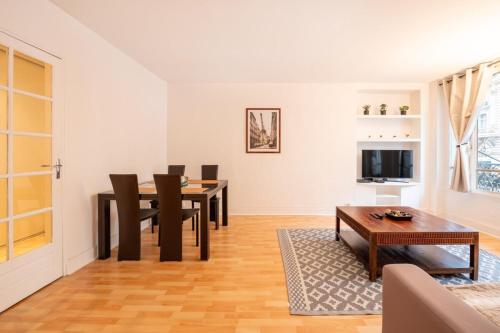 a living room with a table and chairs and a television at Cosy & Well-Connected 1BD ApartmentSaint Lazare in Paris