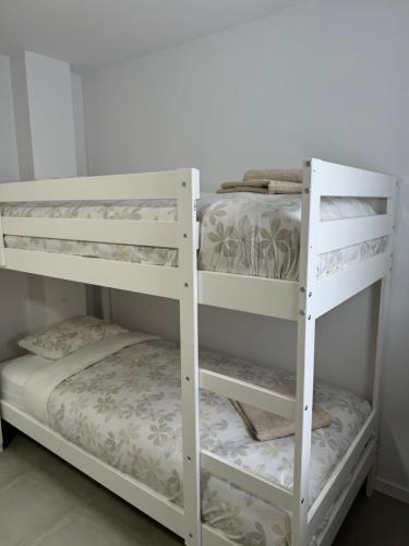 two white bunk beds in a room at UIM Mediterraneo Cendoya 2 Wifi in Puerto de Sagunto